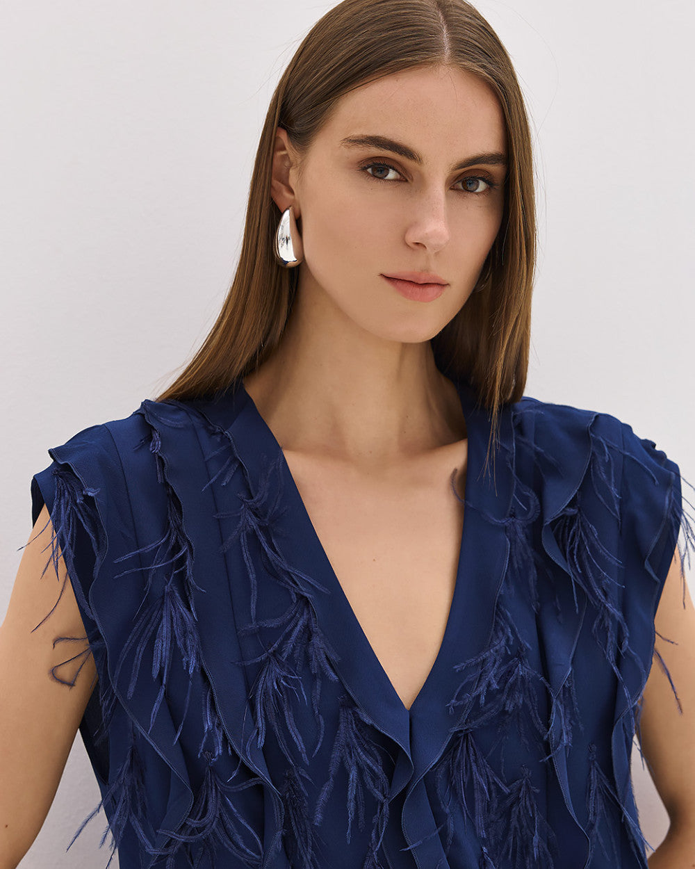 Camicia blu senza maniche con volant e piume