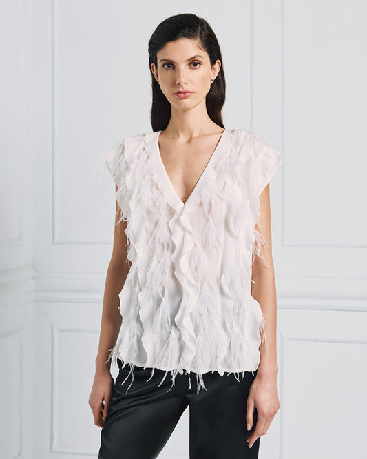 Camicia bianca senza maniche con volant e piume