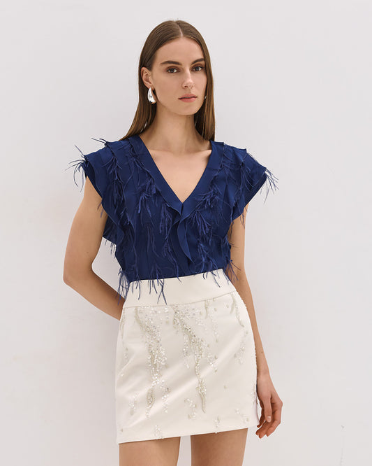 Camicia blu senza maniche con volant e piume