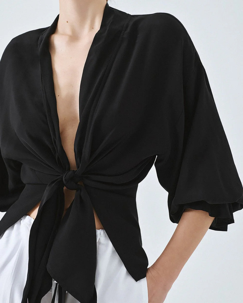 Kimono shirt with tie closure and flounced sleeves.